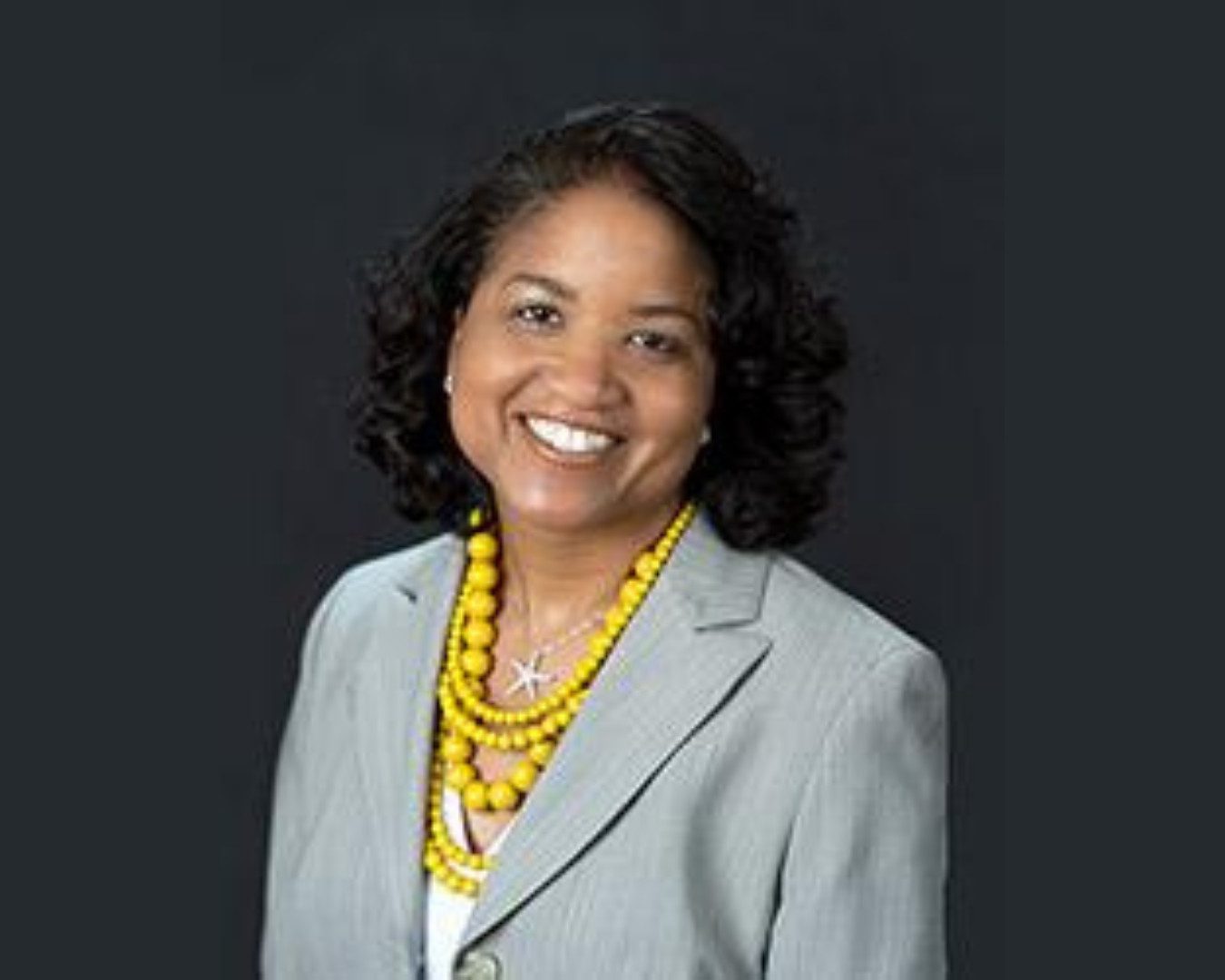 A smiling woman with curly black hair